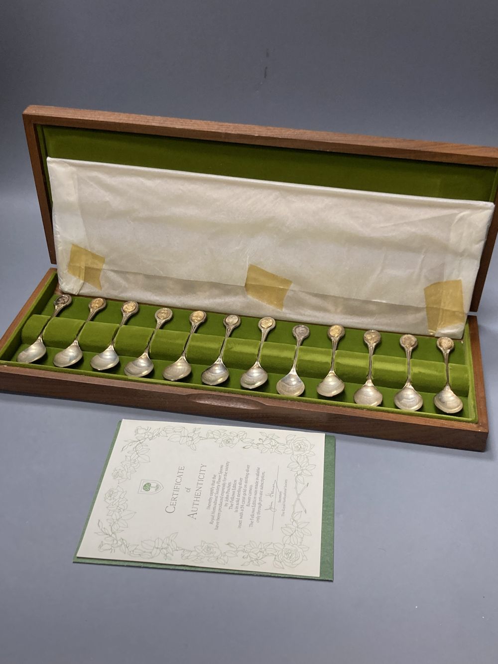 A modern cased set of twelve parcel gilt silver Royal Horticultural Society Flower Spoons by John Pinches,